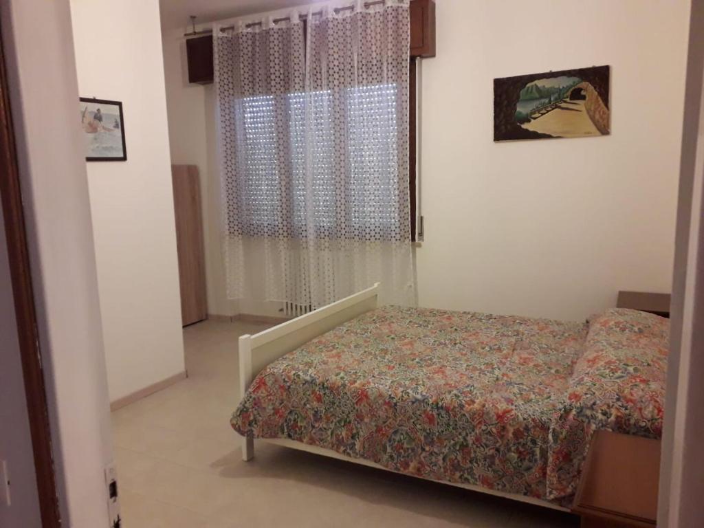 Habitación pequeña con cama y ventana en kola age, en Peschiera del Garda