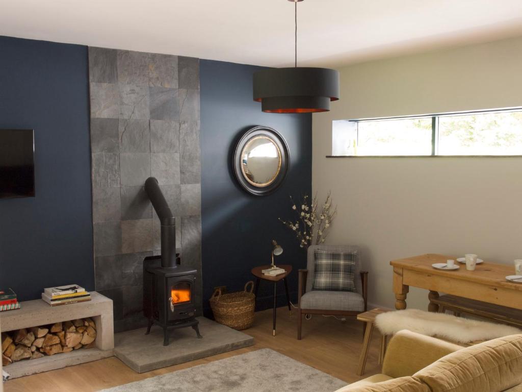 a living room with a fireplace and a couch at Mews Cottage Ardoch Lodge Strathyre in Strathyre