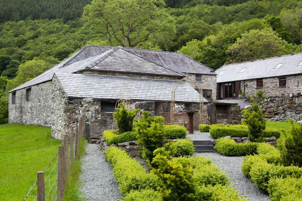 an old stone house with a garden in front of it at Plasglasgwm in Betws-y-coed