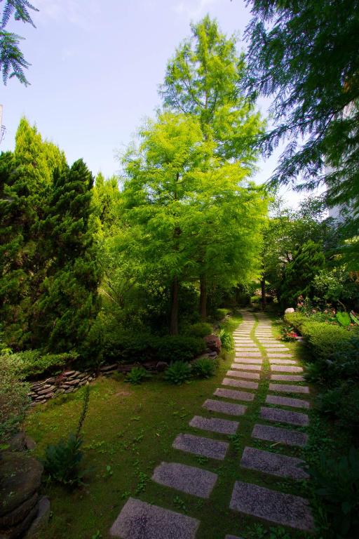a stone path in a garden with trees at Yun Wu B&amp;B in Ren&#39;ai