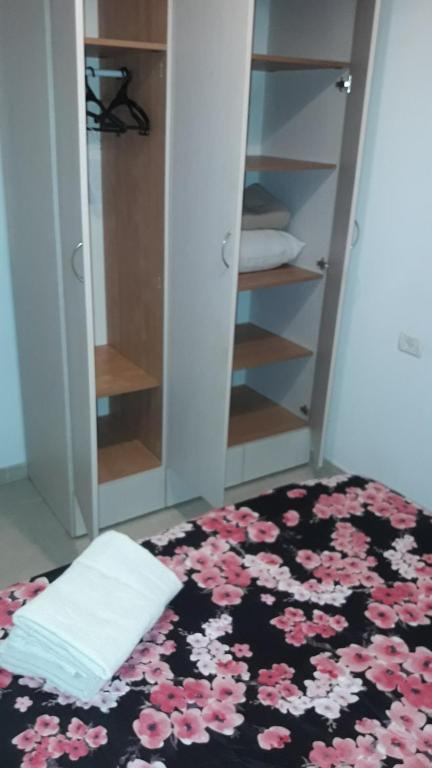 a bedroom with a bed with pink flowers on it at tilis מרגולין 33 תל אביב in Tel Aviv