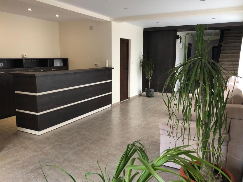 a lobby with a reception desk and a potted plant at Eden Blue in Costinesti