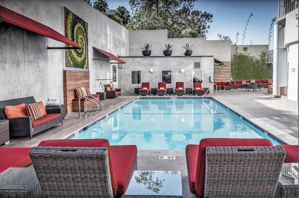 une grande piscine avec des chaises et une table dans l'établissement Hotel Angeleno, à Los Angeles