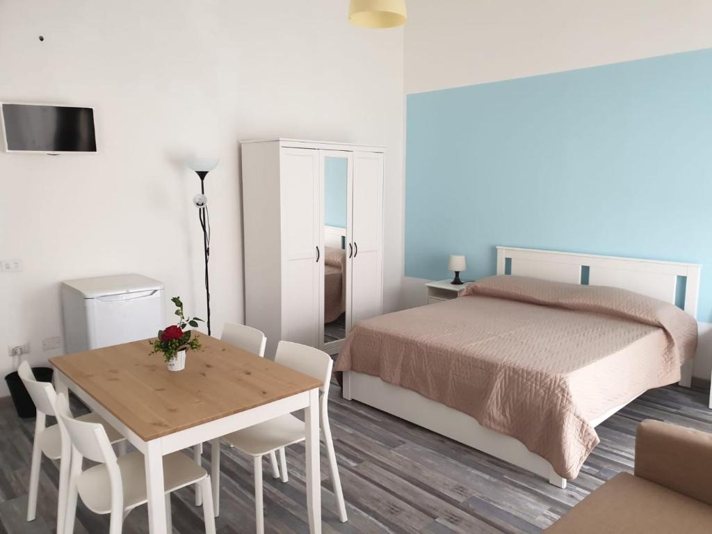1 dormitorio con 1 cama, mesa y sillas en Lipari Suite Apartament, en Lipari