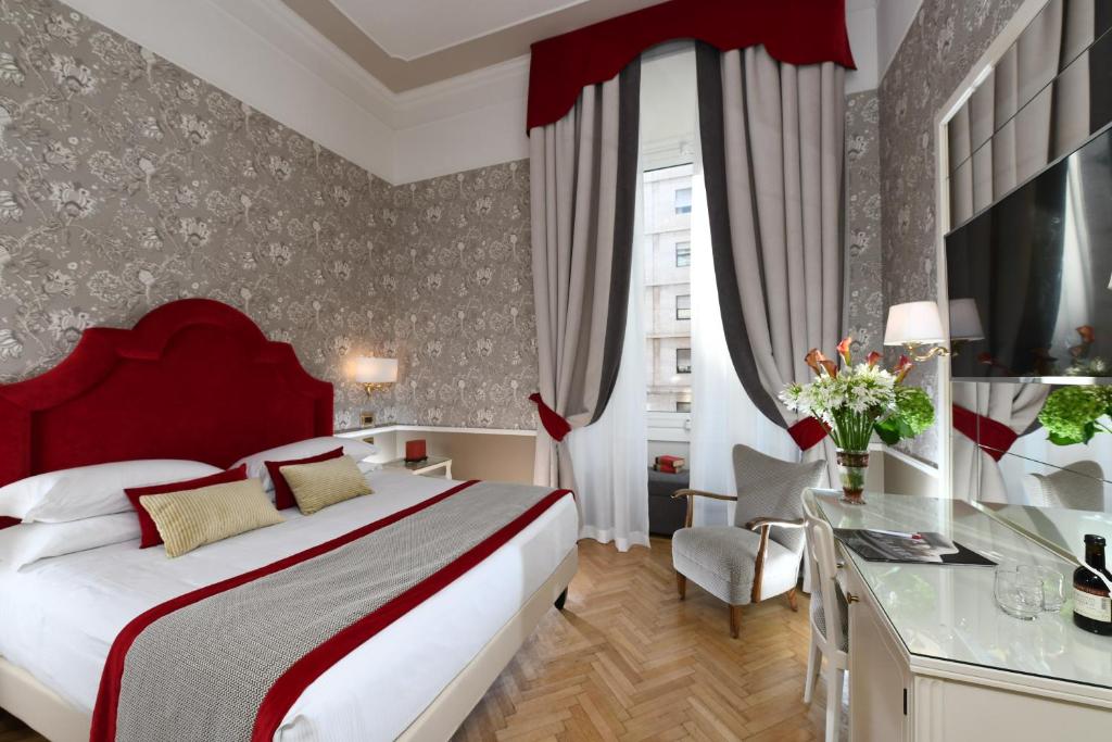 um quarto de hotel com uma cama grande e uma secretária em Bettoja Hotel Massimo d'Azeglio em Roma