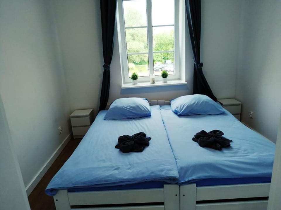 a bedroom with a bed with two black gloves on it at Apartament w starej kamienicy in Mrągowo