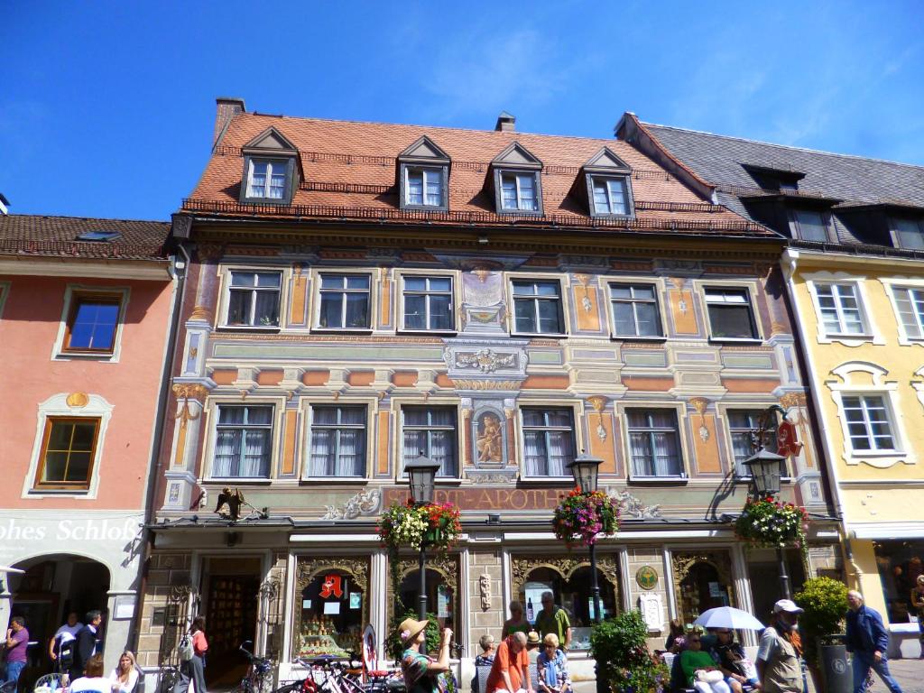 um grande edifício com pessoas andando na frente dele em Lucky Home Ludwig Appartment em Füssen