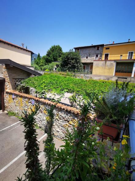 a stone wall with plants on the side of a building at Il Cortile in Clusane sul Lago
