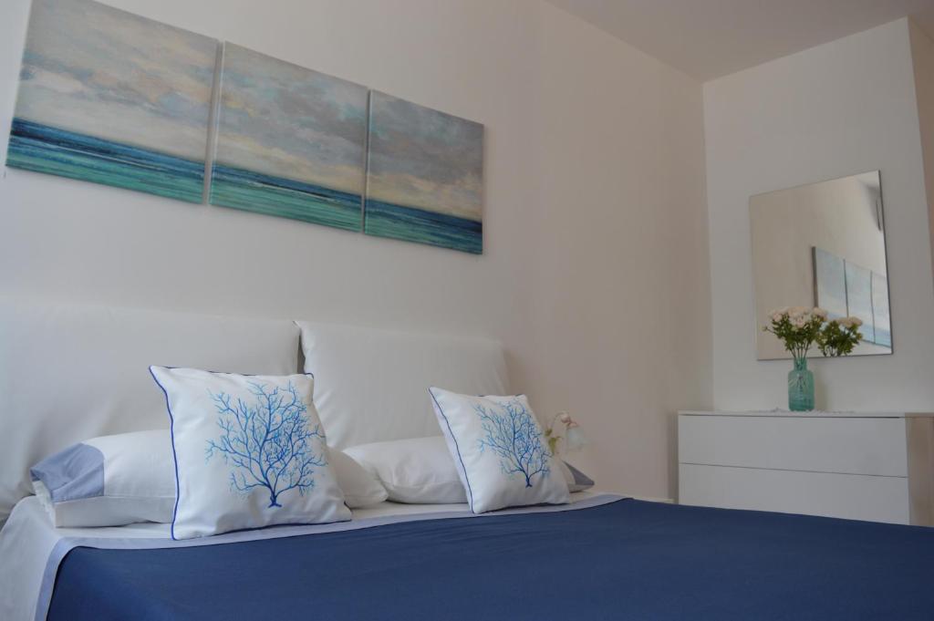 ピアノ・ディ・ソレントにあるBaia della Serenitàのベッド(青と白の枕、絵画付)