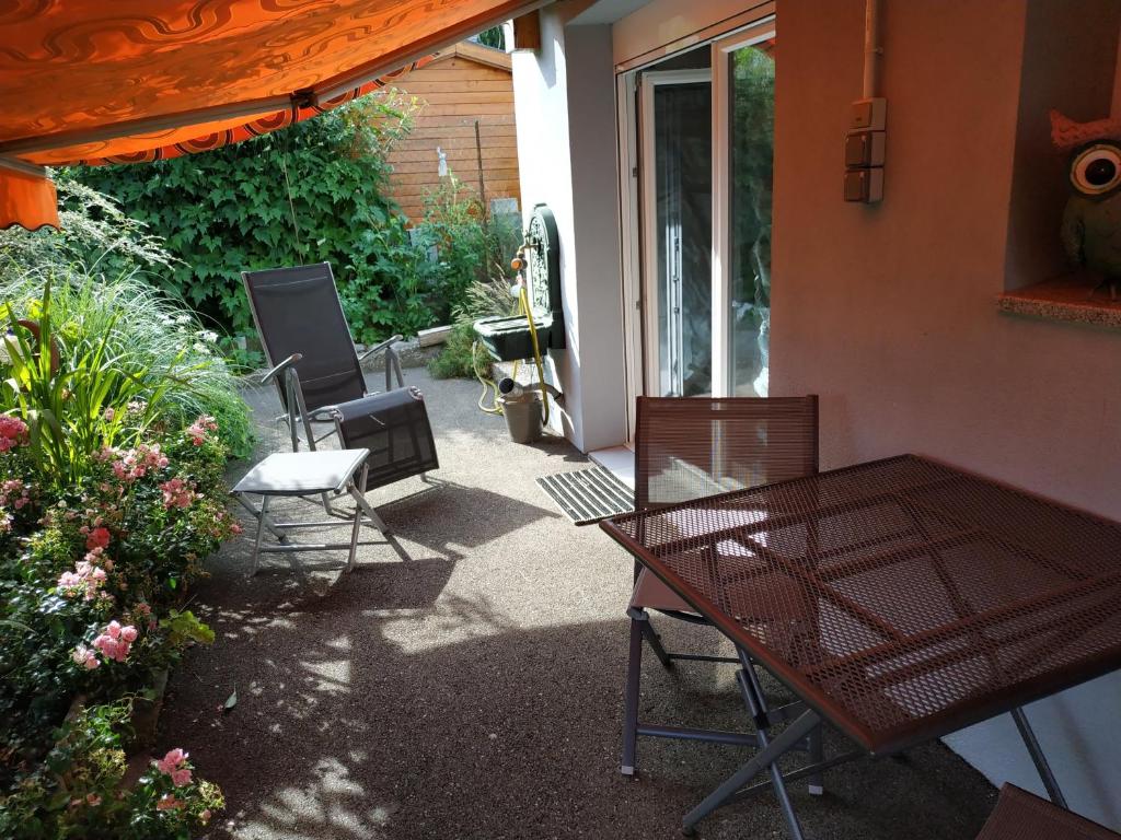 eine Terrasse mit einem Tisch und Stühlen neben einem Gebäude in der Unterkunft Joli gîte proche Strasbourg in Breuschwickersheim