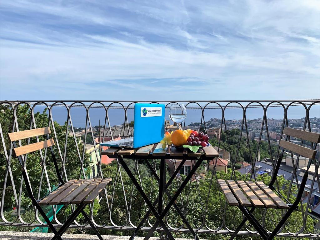 a table with a laptop on top of a balcony at House Blue Sky by Holiday World in Genoa