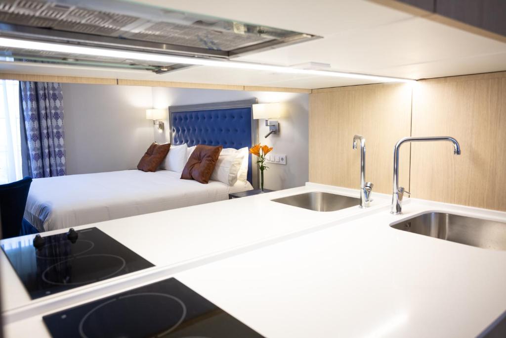 a hotel room with a sink and a bed at Plazuela del Carbón Suites in Cádiz