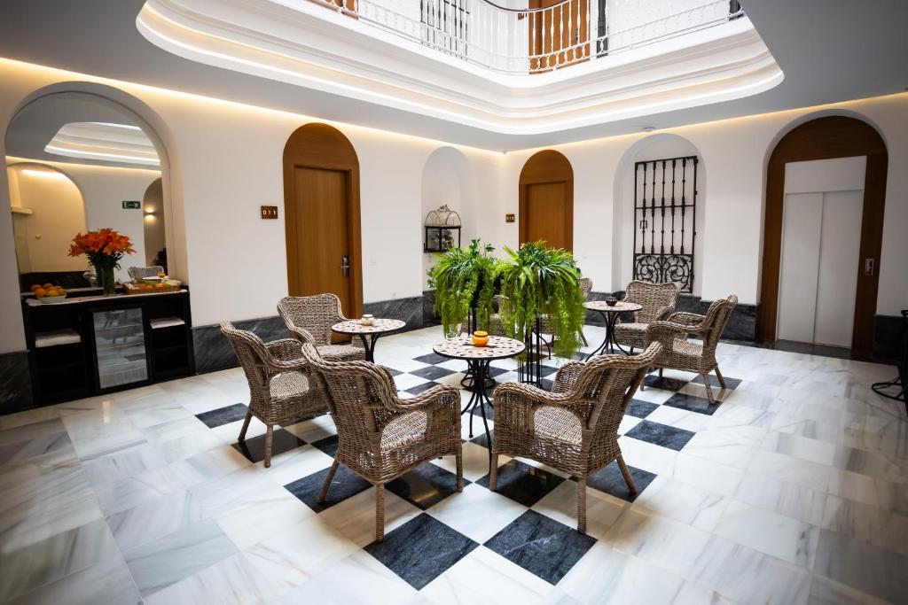 a dining room with tables and chairs in a building at Plazuela del Carbón Suites in Cádiz