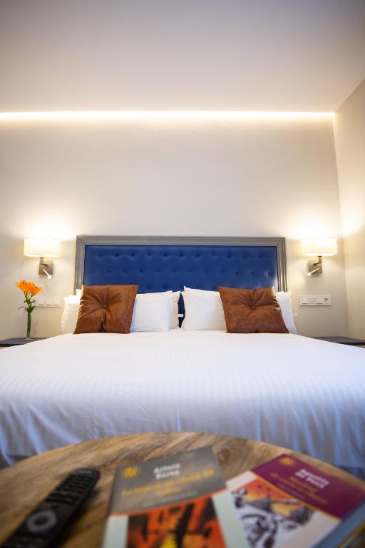a bedroom with a large white bed and a table at Plazuela del Carbón Suites in Cádiz