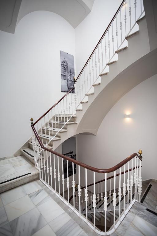 a staircase in a house with white walls and white floors at Plazuela del Carbón Suites in Cádiz