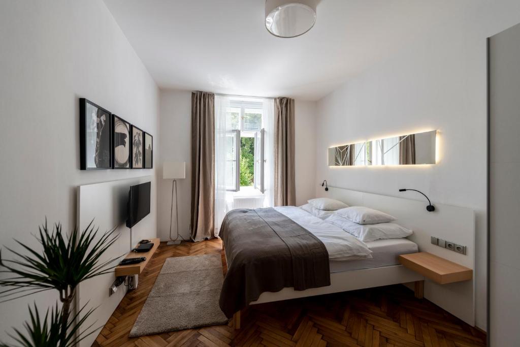 a white bedroom with a bed and a window at Apartment Slavikova 11 in Prague