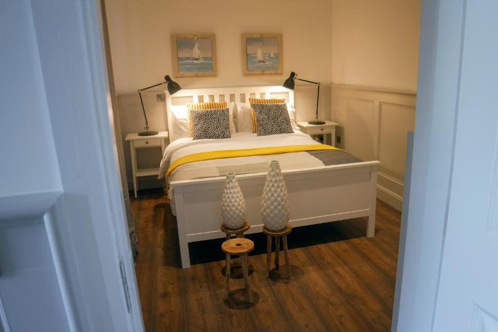 a bedroom with a bed with two lamps on it at The Nest in Youghal