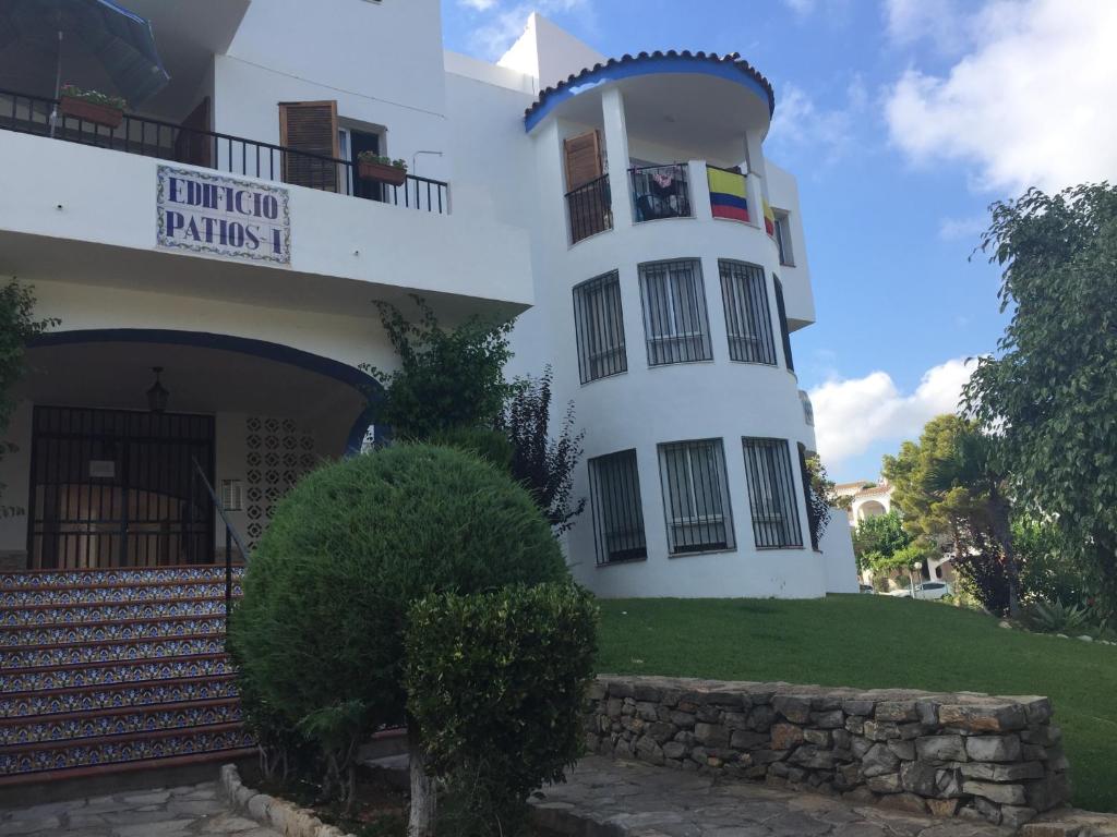 un edificio blanco con una torre de reloj delante en Patios I, en Peñíscola