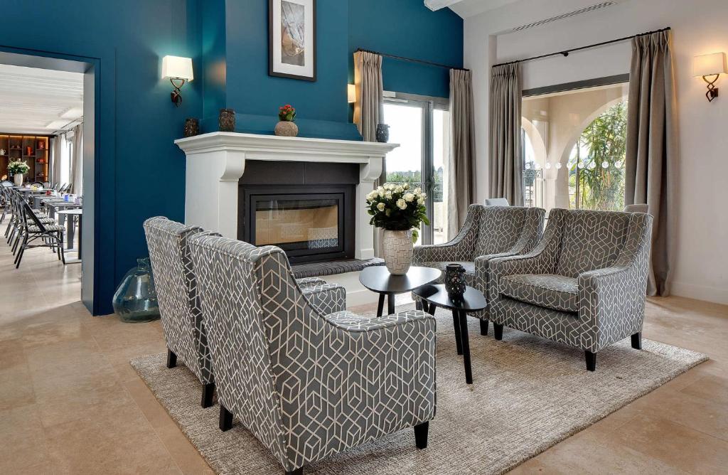 a living room with chairs and a fireplace at La Bastide de Biot in Biot