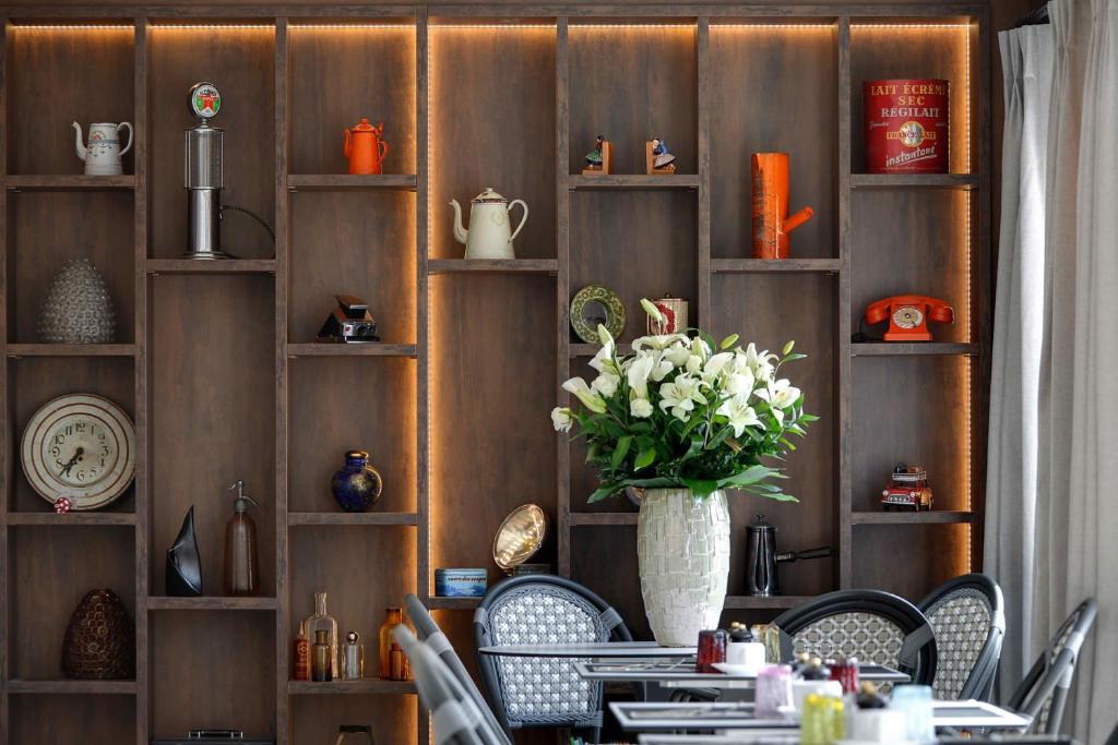 a dining room with a table with chairs and a vase with flowers at La Bastide de Biot in Biot