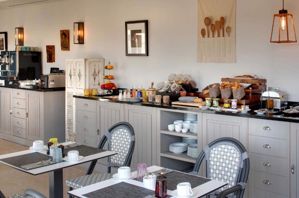a restaurant with two tables and chairs and a counter at La Bastide de Biot in Biot