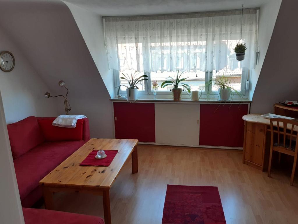 a living room with a red couch and a table at Ferienwohnung Altstadtflair in Schweinfurt