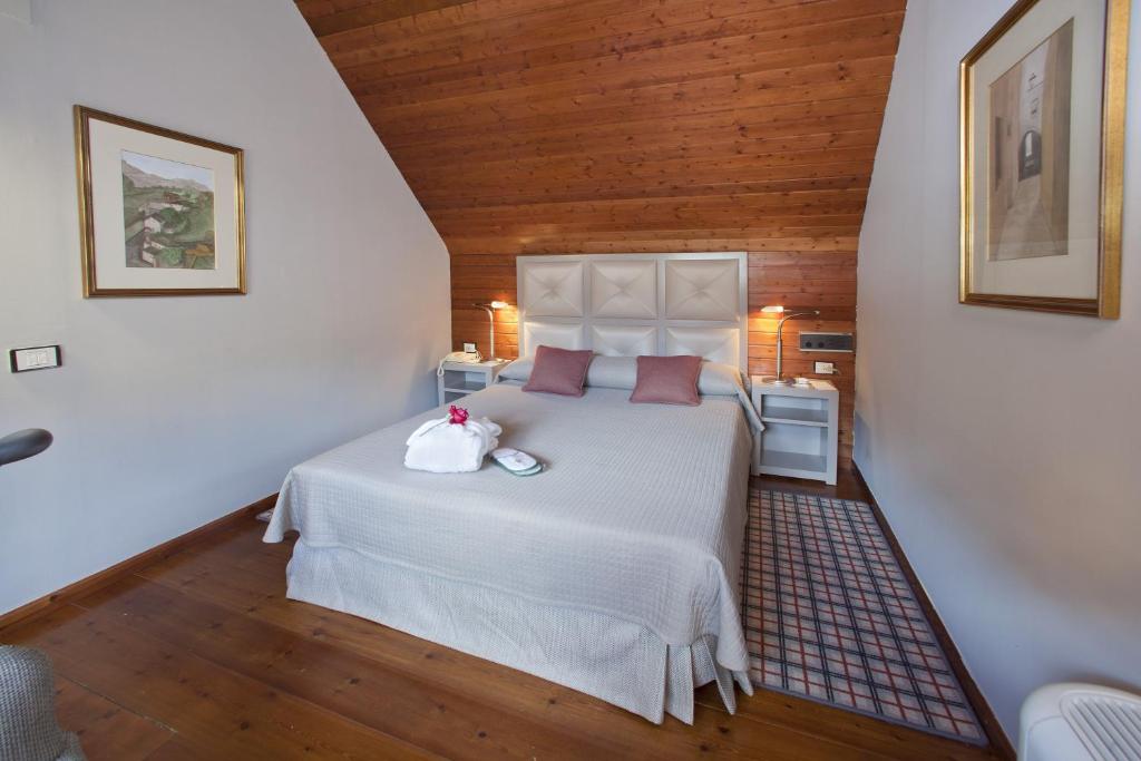 a bedroom with a white bed with a wooden ceiling at Parador de Artíes in Arties