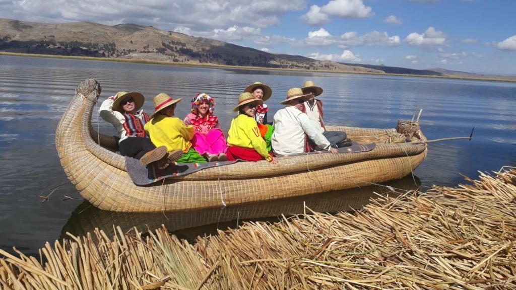 a group of people sitting in a boat on the water at Uros Titicaca Aru Lodge in Puno