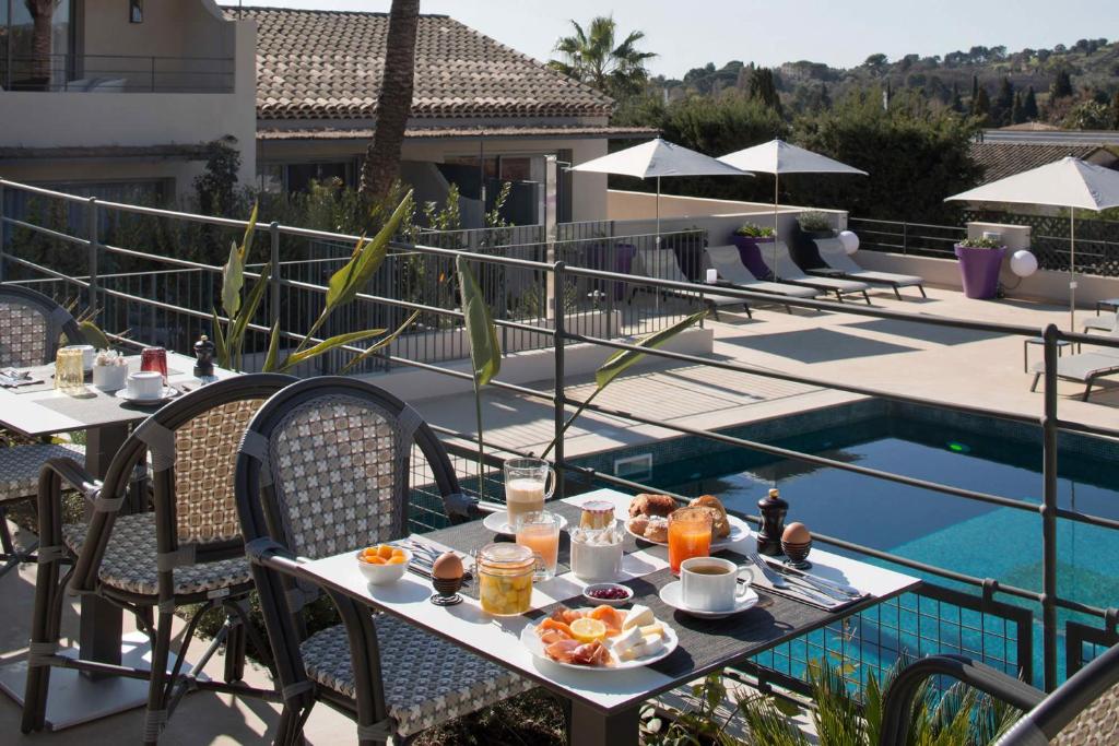 a table with food on it next to a pool at La Bastide de Biot in Biot