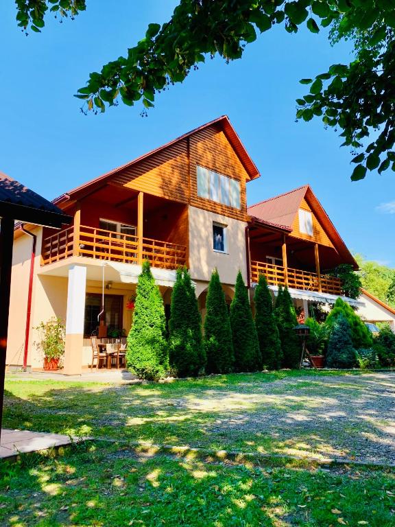 a large wooden house with a lot of trees at Янтарная форель in Bushtyno