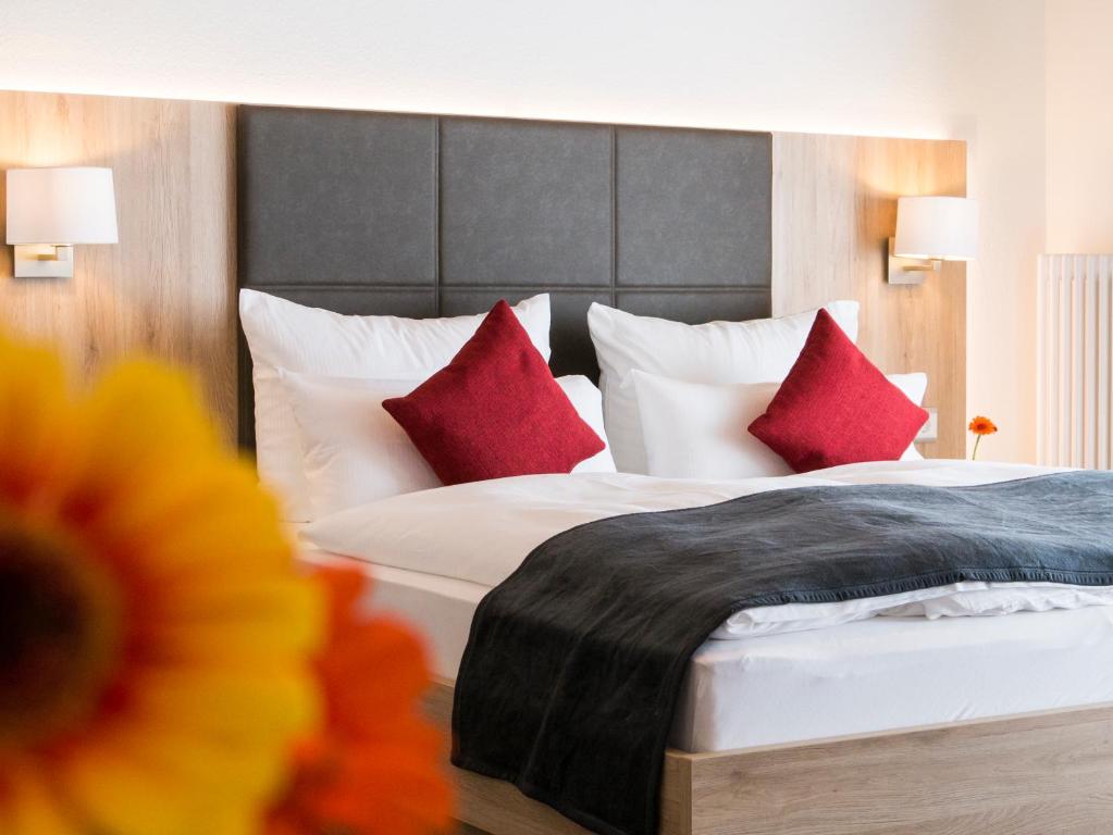 カッペル・グラーフェンハウゼンにあるHotel Restaurant Schiffの赤い枕のベッドが備わるホテルルームです。
