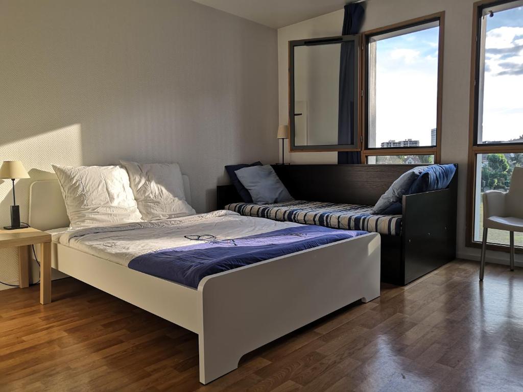 1 dormitorio con 1 cama y 1 sofá en Studio lumineux 10 min à La Défense en Rueil-Malmaison