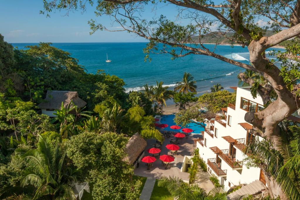 Hotel Ysuri Sayulita في سايوليتا: اطلالة جوية للفندق والشاطئ