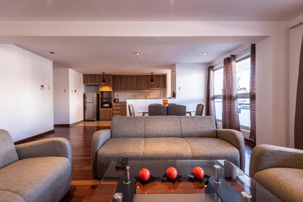 sala de estar con 2 sofás y cocina en El Triunfo Apartments, en Cusco