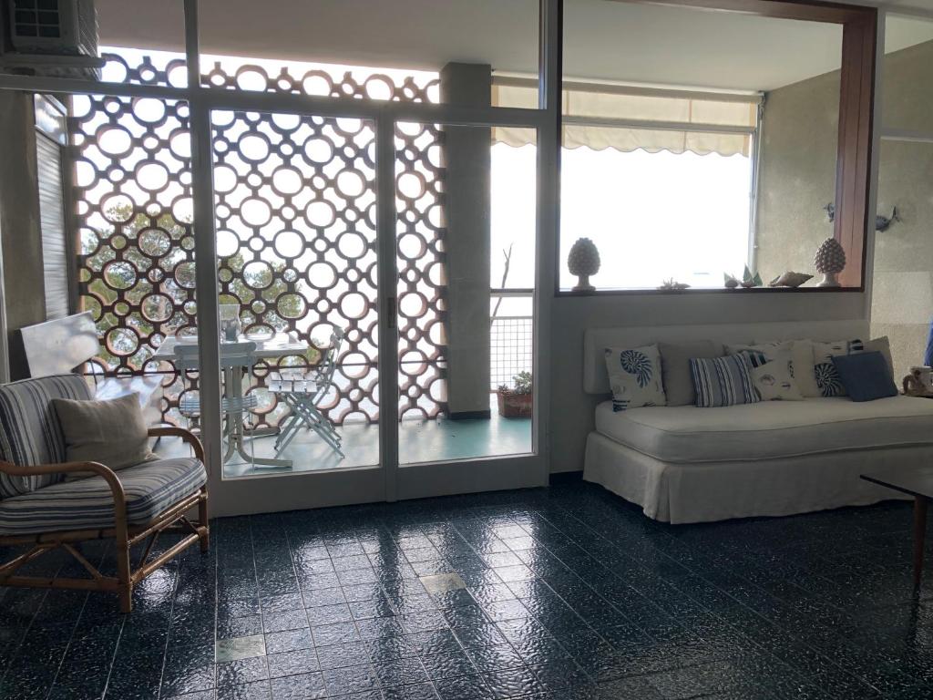 uma sala de estar com um sofá e uma janela em LIGURIA HOLIDAYS - Sulla scogliera con spiaggia privata em Sori