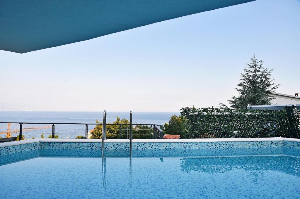 a swimming pool with a view of the ocean at Apartments in Villa Ziza, rooftop swimming pool in Opatija