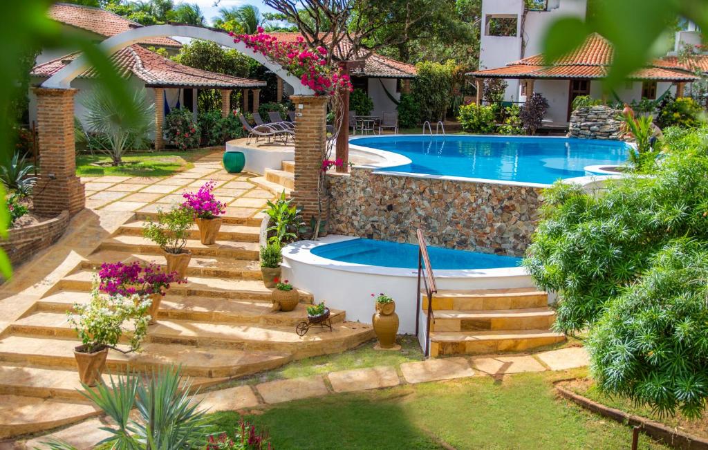 un patio trasero con piscina y bañera en Espaço Nova Era Pousada, en Jericoacoara