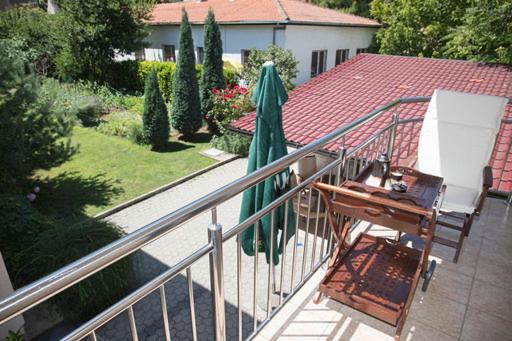 einen Balkon mit einem Tisch, einem Stuhl und einem Sonnenschirm in der Unterkunft Apartman Mona in Mostar