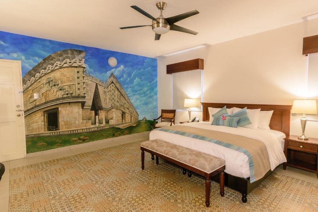 a bedroom with a large bed and a painting on the wall at Hotel Boutique Real San Juan Center in Mérida