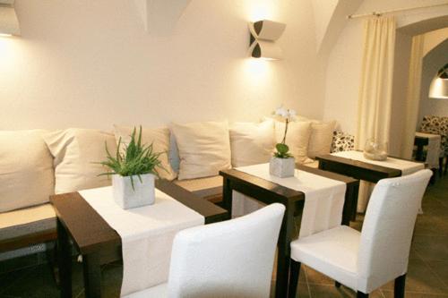 a living room with a couch and tables and white chairs at deckerts Hotel am Katharinenstift in Lutherstadt Eisleben