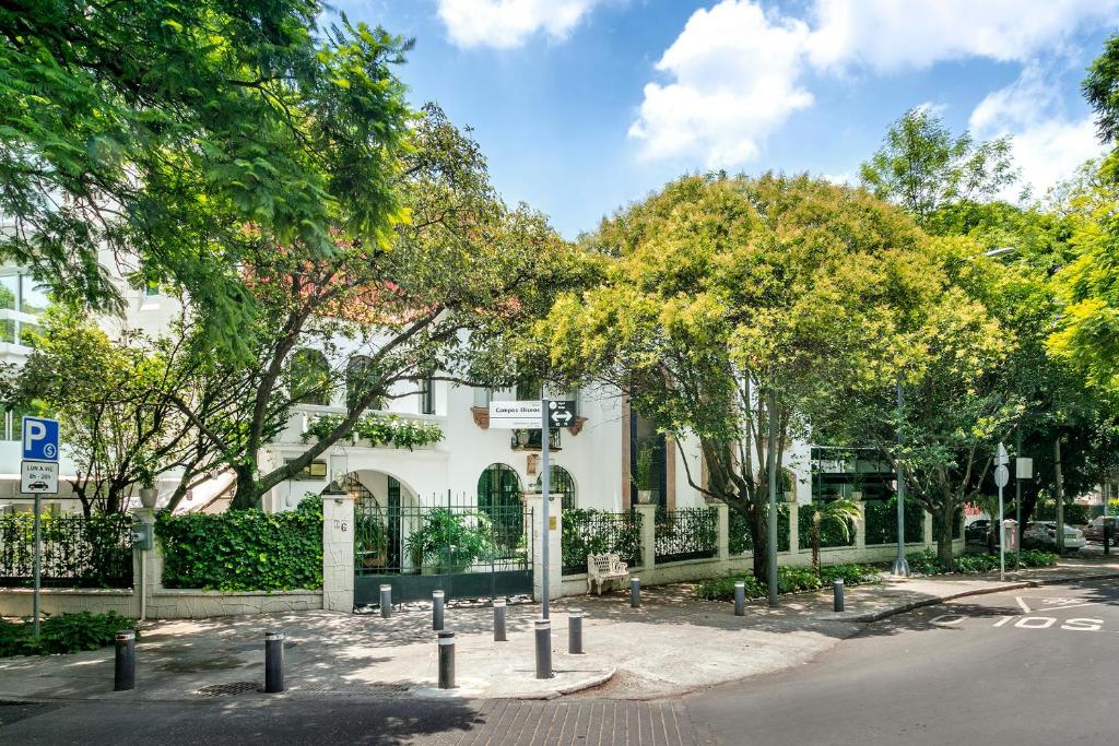 a building with a fence and trees and a street at Orchid House Polanco in Mexico City