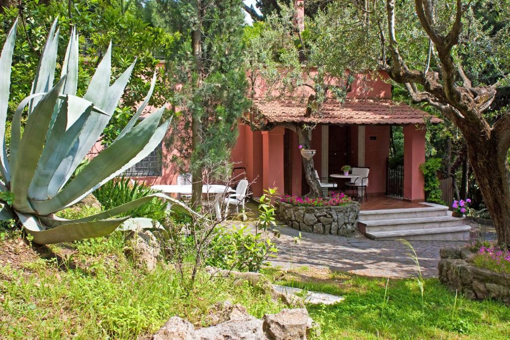 un giardino con una casa con tavolo e sedie di La Dolce Casetta a Grottaferrata