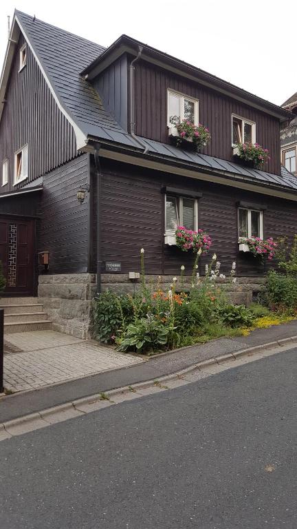una casa marrón con flores delante en Ferienwohnung Müller, en Steinach