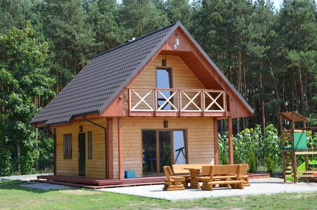 una piccola cabina con tetto nero e panche di Sosenka - całoroczne domki rekreacyjne a Milicz