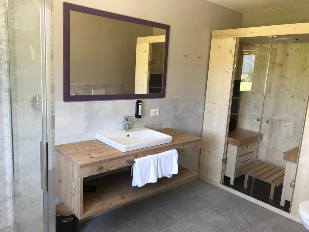 un bagno con lavandino e specchio di Klein Fein Hotel zum Graf a Valle Di Casies