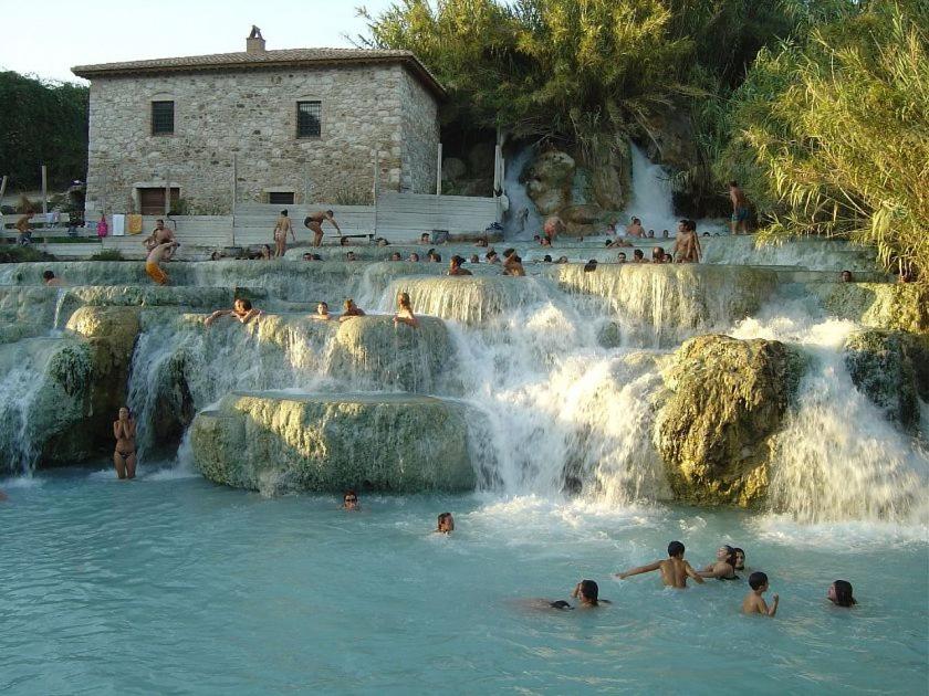grupa ludzi pływających w wodospadzie w obiekcie Appartamento indipendente vista unica w mieście Manciano