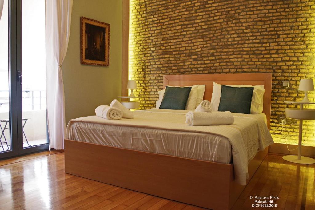 アテネにあるAthens Historic Centre Renovated Apartmentsのレンガの壁のベッドルーム1室(大型ベッド1台付)