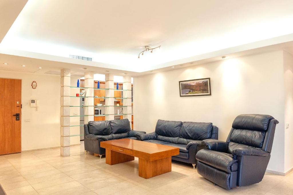 a living room with couches and a coffee table at Apartment in Amdar Residence in Eilat