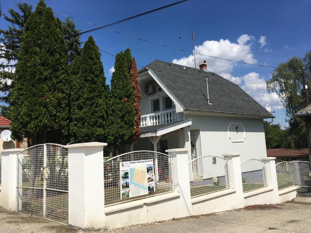 una cerca blanca frente a una casa blanca en Tassi Halászcsárda-Kárász ház, en Tass
