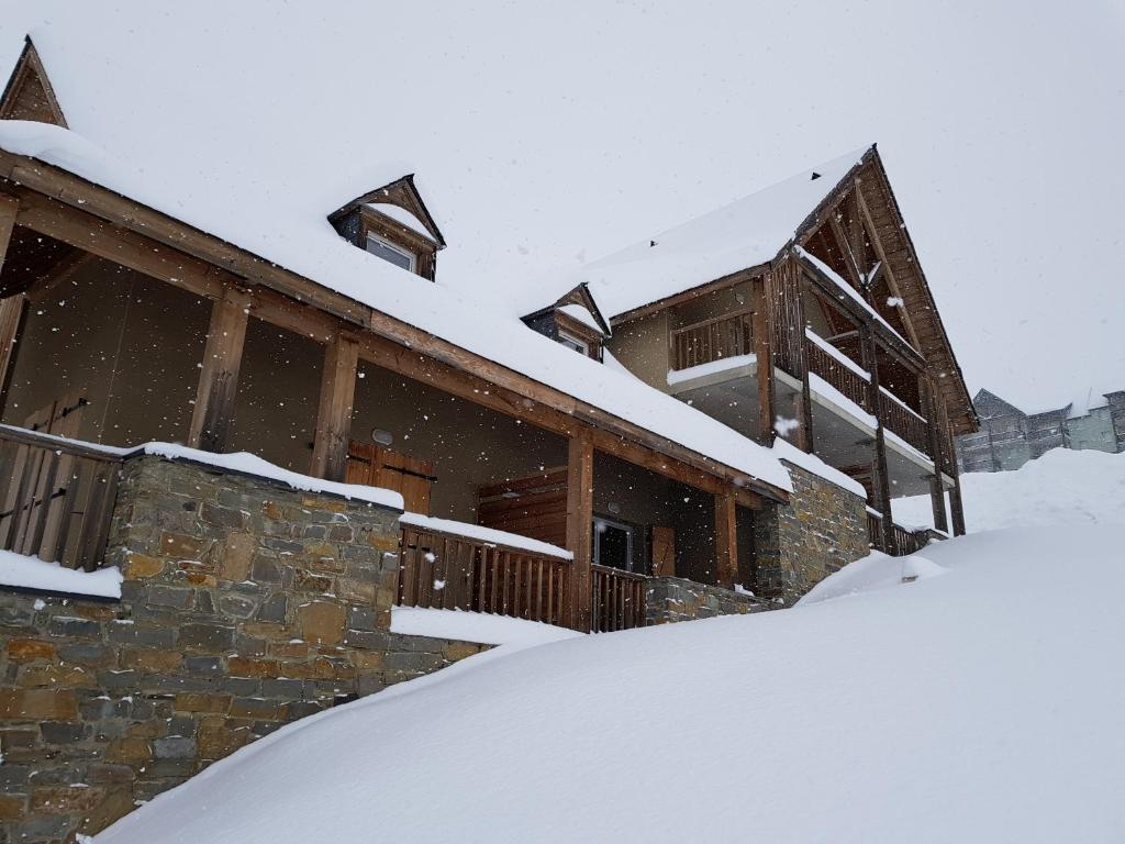 een huis bedekt met sneeuw met een berg sneeuw bij Chevêche in Germ